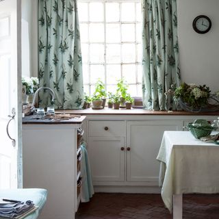 kitchen with flower pots and floral curtains