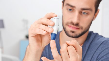 Man taking blood sample with lancet pen.