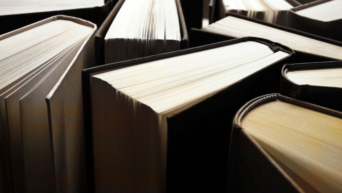 Old books arranged so that no text, author&#039;s name or publisher is visible. Day light. Retouched photograph. Paris, France.