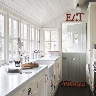 kitchen with gray door and white windows