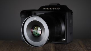 Hasselblad XCD 75P lens on a Hasselblad X2D camera, on a wooden surface against a dark background