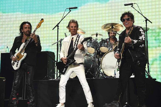 Marco Mendoza, Jonathan Cain and Neil Schon onstage. 