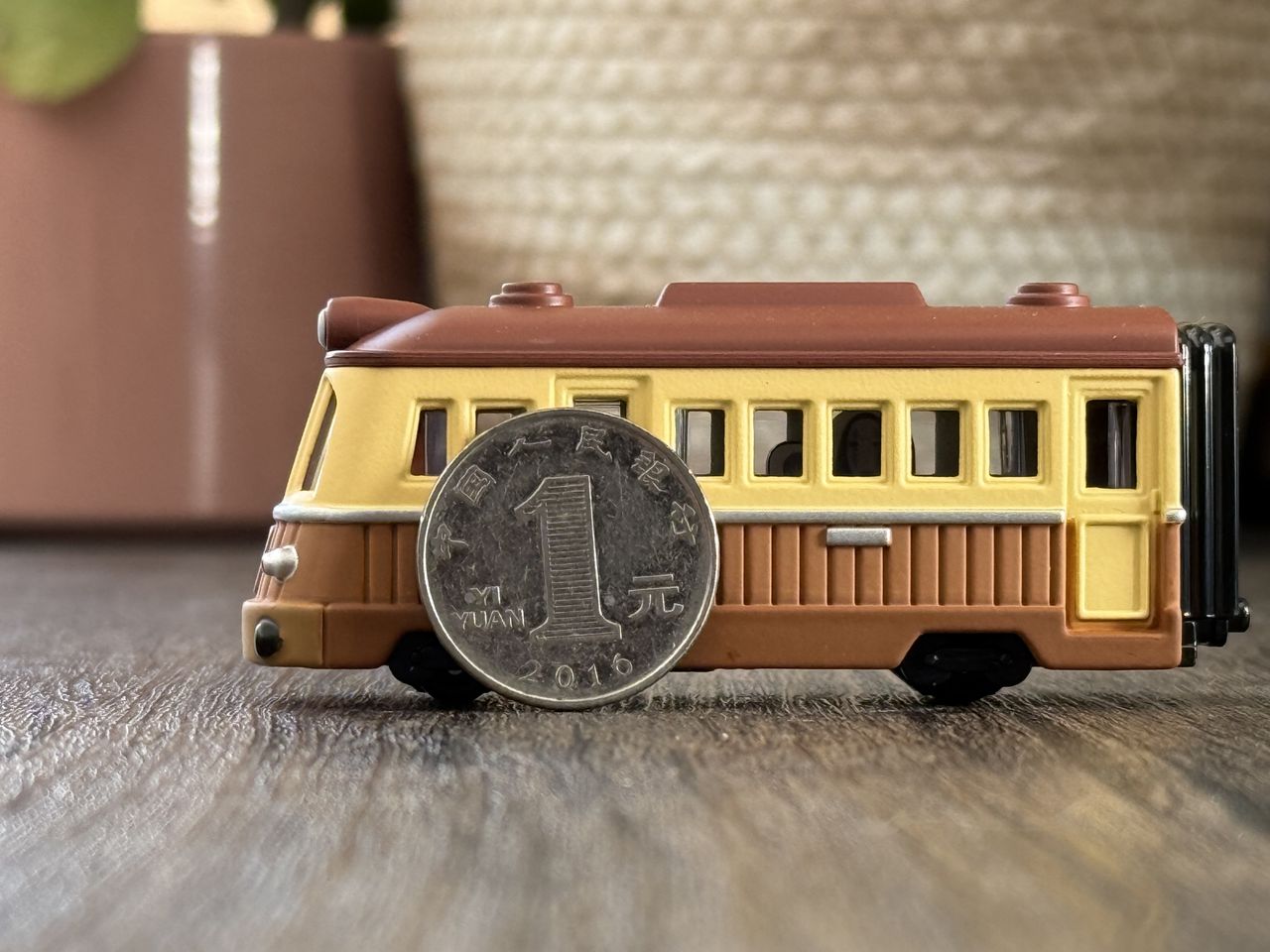 A coin propped up against a train on a wooden table