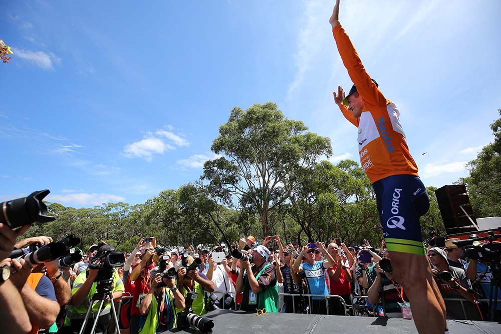 Simon Gerrans waves to the crowd after pulling on the leader's jersey