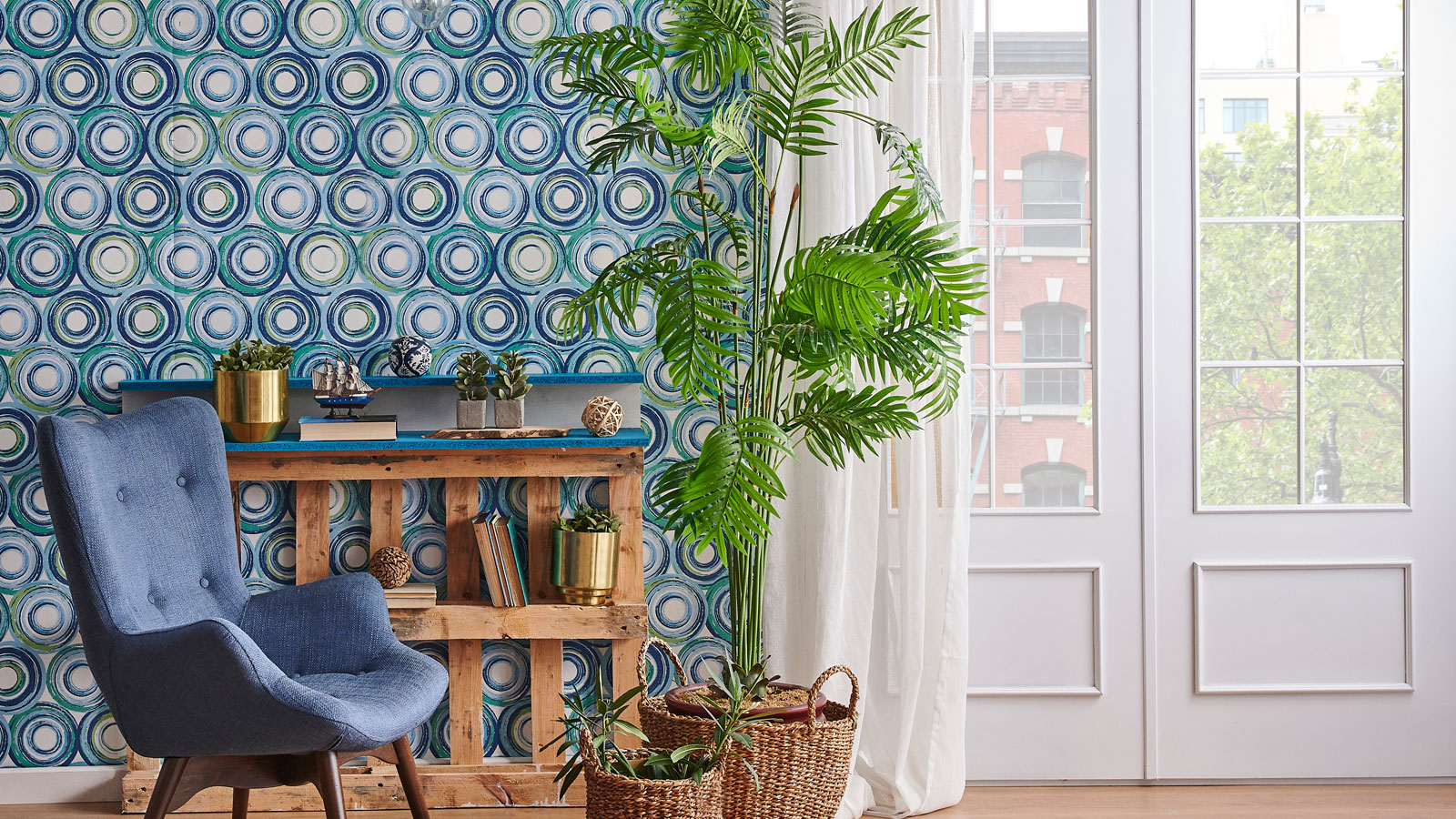 Contemporary living room with blue wallpaper behind blue chair and plants