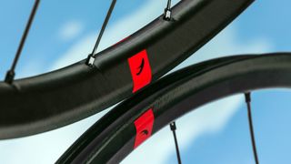 A close up of two Fulcrum rims touching, with the red Fulcrum logos aligned, in front of a cloudy sky background