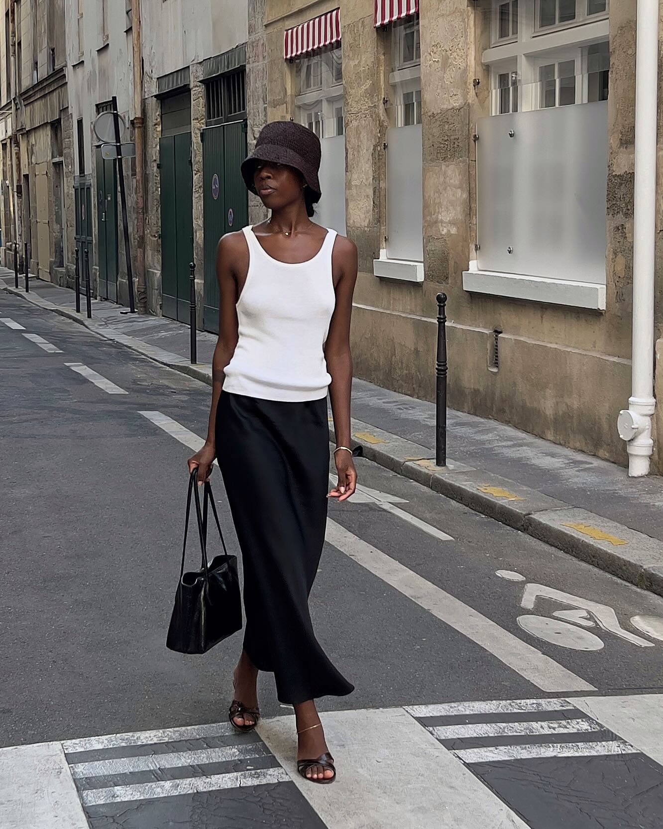 An image of @sylviemus_ wearing a white tank top, one of the best '90s summer trends coming back in 2026.