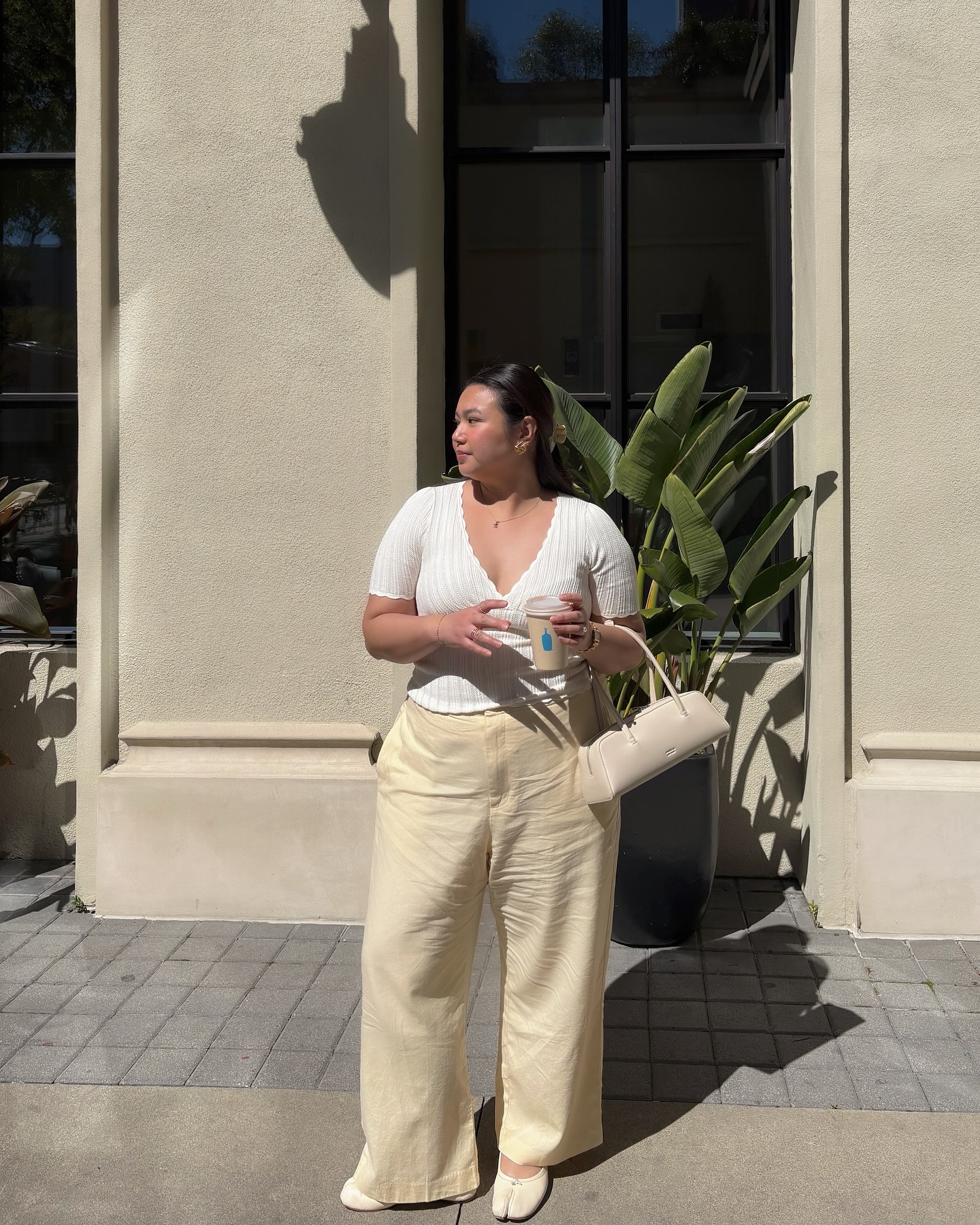 An image of @marina_torres wearing a crochet top with straight-leg pants.