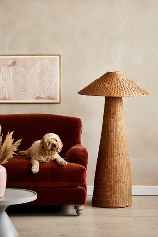 large rattan floor lamp and red velvet sofa