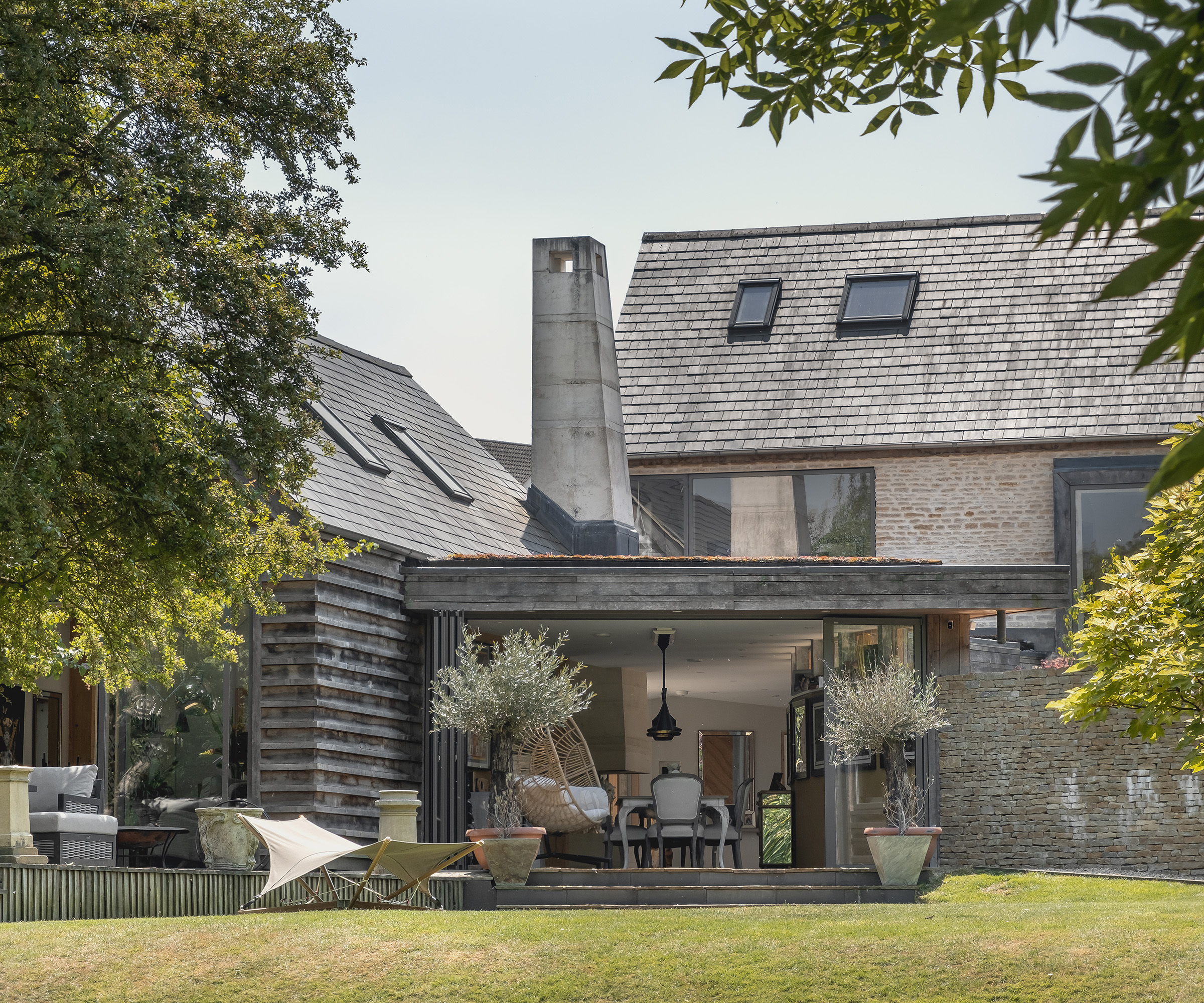 Rear exterior of a self build home with large sliding glass doors and lawn