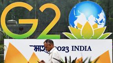 A man in front of a poster background saying G20 2023