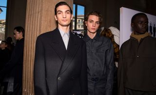 Three male models wearing clothing by Salvatore Ferragamo in dark shades.