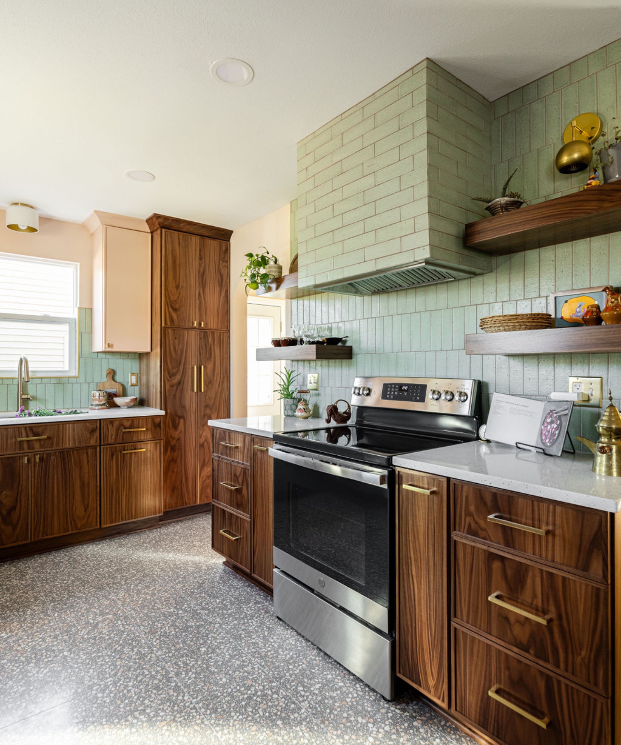 A retro kitchen with walnut cabinets and a green tiled backsplash continued over the range hood