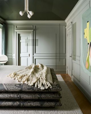 a stylish sage green bedroom with a painted ceiling
