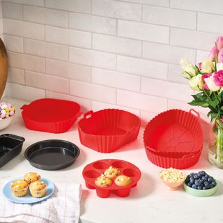 Red silicone air fryer liners and trays on kitchen worktop