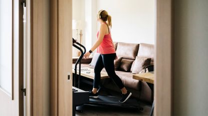 Woman doing the 12-3-30 workout on walking pad at home
