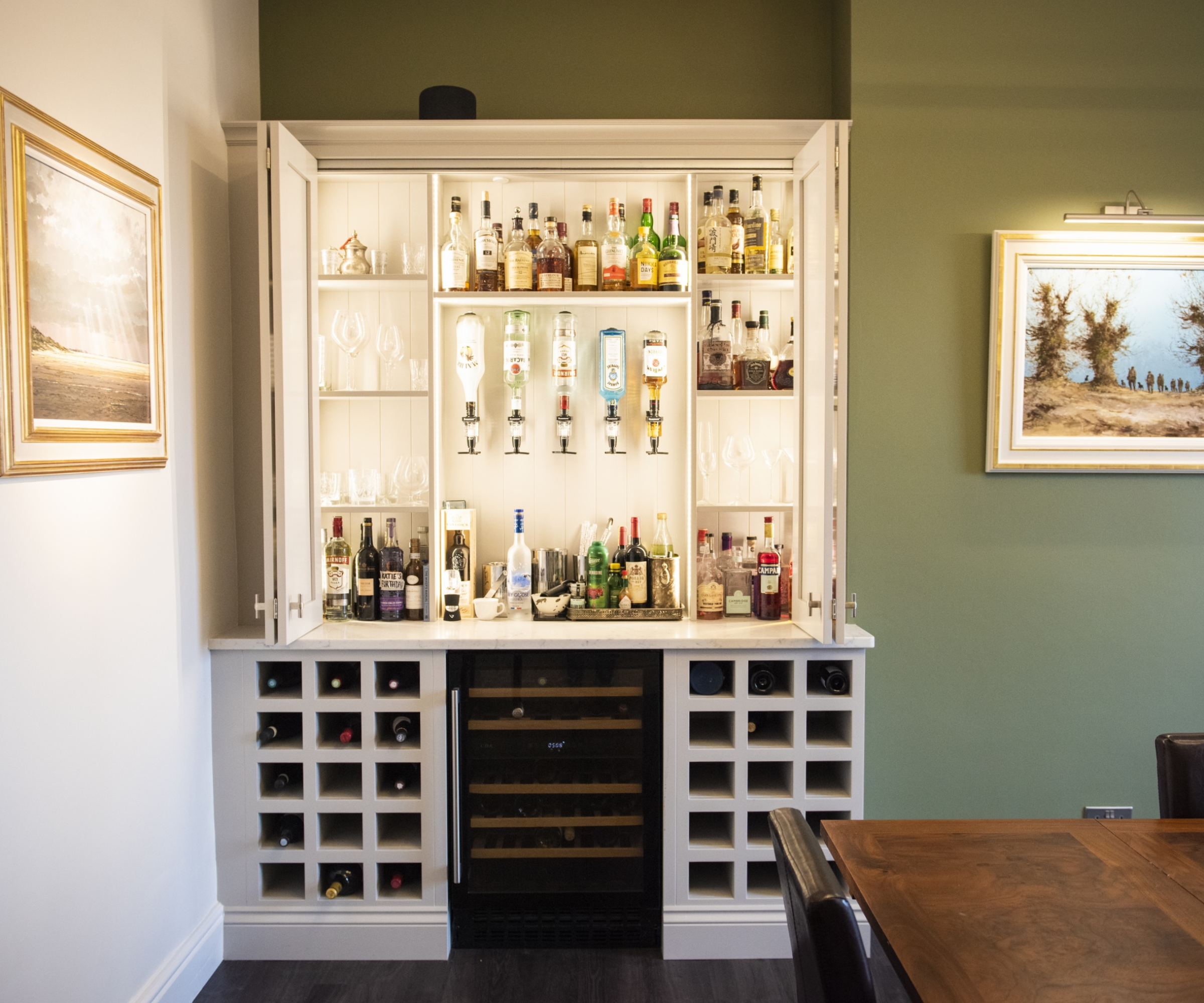 built in bar and wine storage in dining room with green feature wall