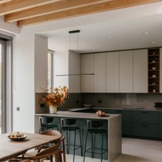contemporary kitchen dining area with breakfast bar, bar stools, wall units, long dining table 
