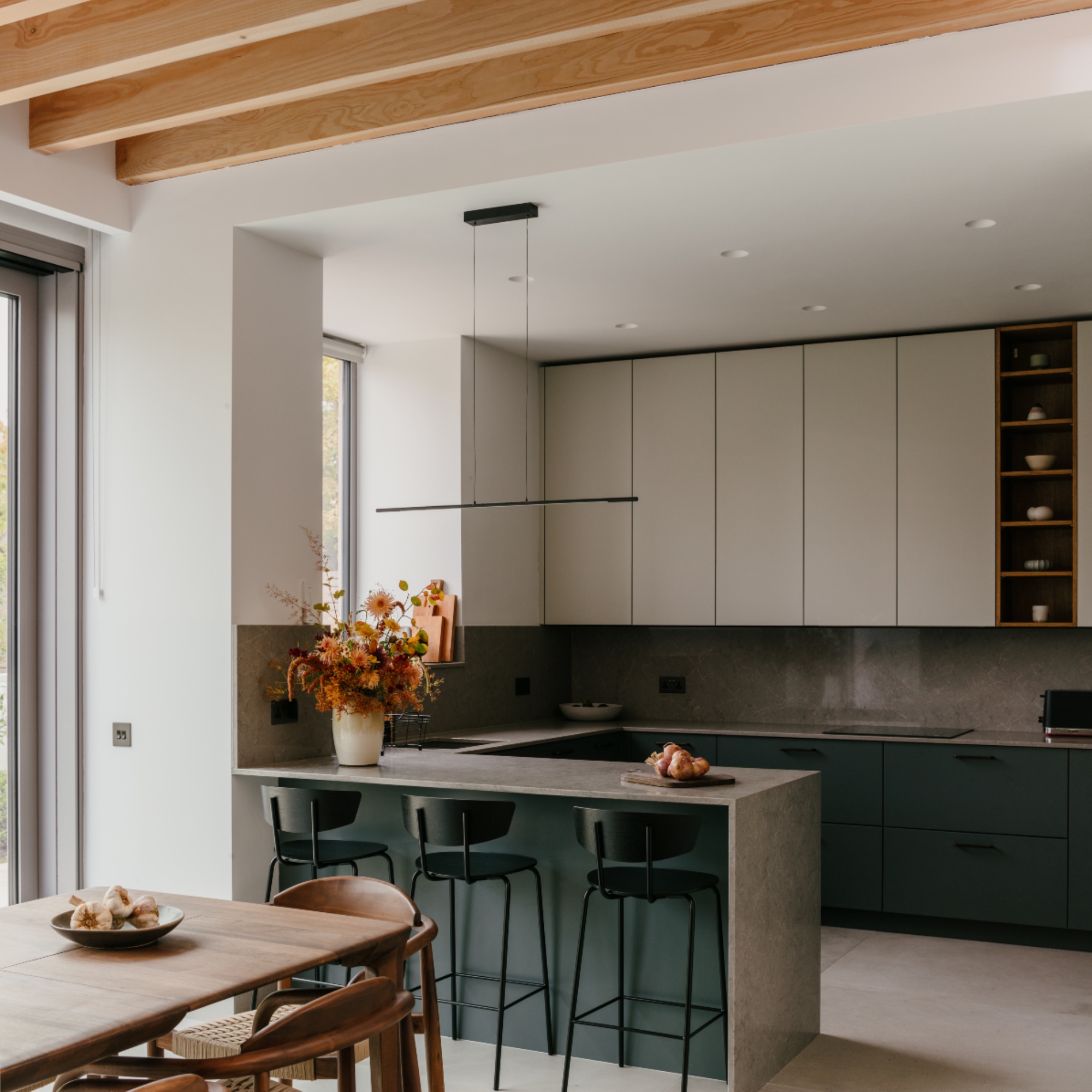 contemporary kitchen dining area with breakfast bar, bar stools, wall units, long dining table