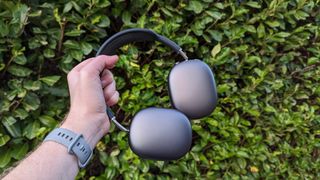 Our reviewer clutching onto the first-gen AirPods Max noise-cancelling headphones