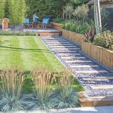 Striped lawn with a garden path and garden border surrounding it