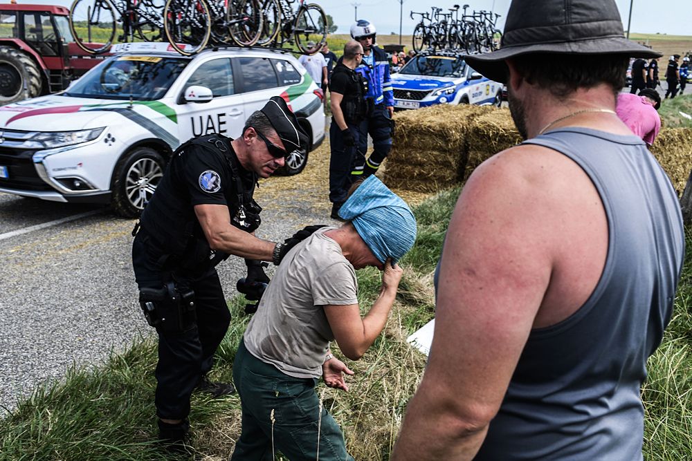 Gendarmes detain a protester during a farmers' protest who attempted to block the stage's route, during the 16th stage of the 105th edition of the Tour de France