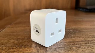 The side view of the Philips Hue smart plug on a wooden countertop