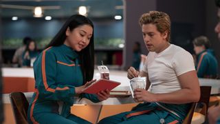 LANA CONDOR as Sophie and COLE SPROUSE as Walt seated at a table in MOONSHOT