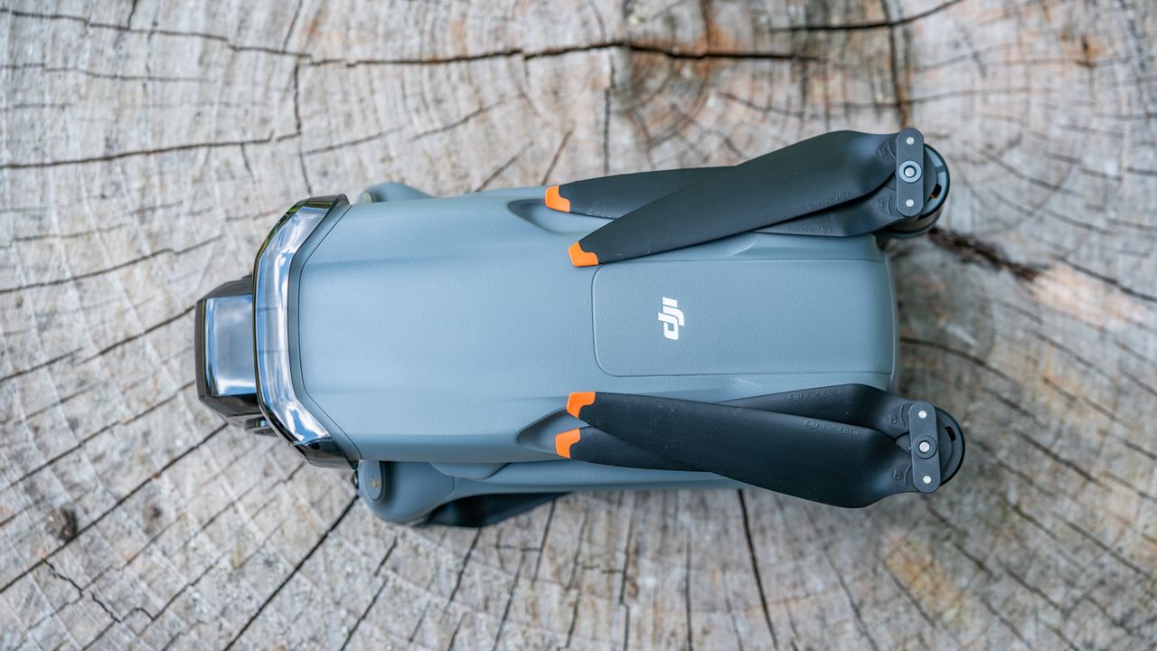 DJI Air 3 drone on a tree stump with arms and propellors folded away and seen directly from above