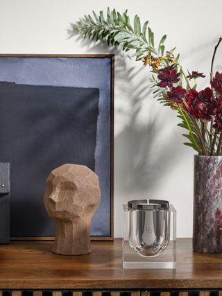 sculptural candleholders and flower vase on wooden table