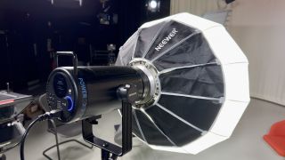 Neewer CB200C COB RGB LED video light with a lantern softbox attached in a tv studio