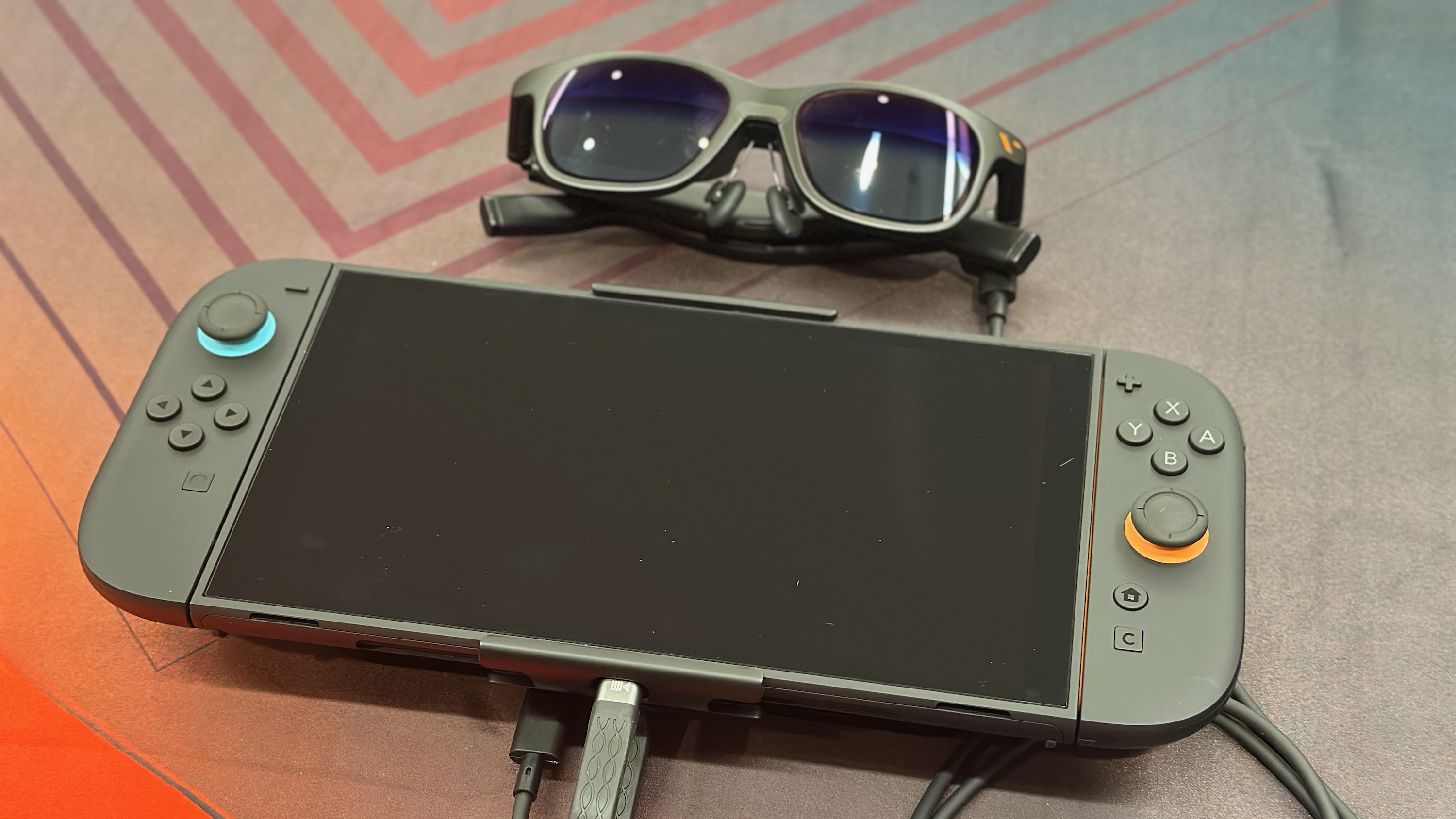 The Nintendo Switch 2 sitting on a table with Viture Pro XR glasses sitting above it.