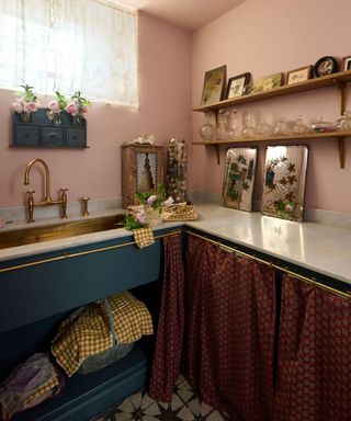 pink laundry room with gallery shelving, white countertops and cabinet cafe curtains