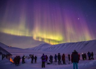 When photographing cosmic events, should sometimes it's good to focus on the ground as well as the sky, said astrophotographer Kevin Morefield. Shown here, a shot by Morefield of the northern lights over Svalbard, Norway, in 2015, and a crowd of skywatchers viewing the light show.