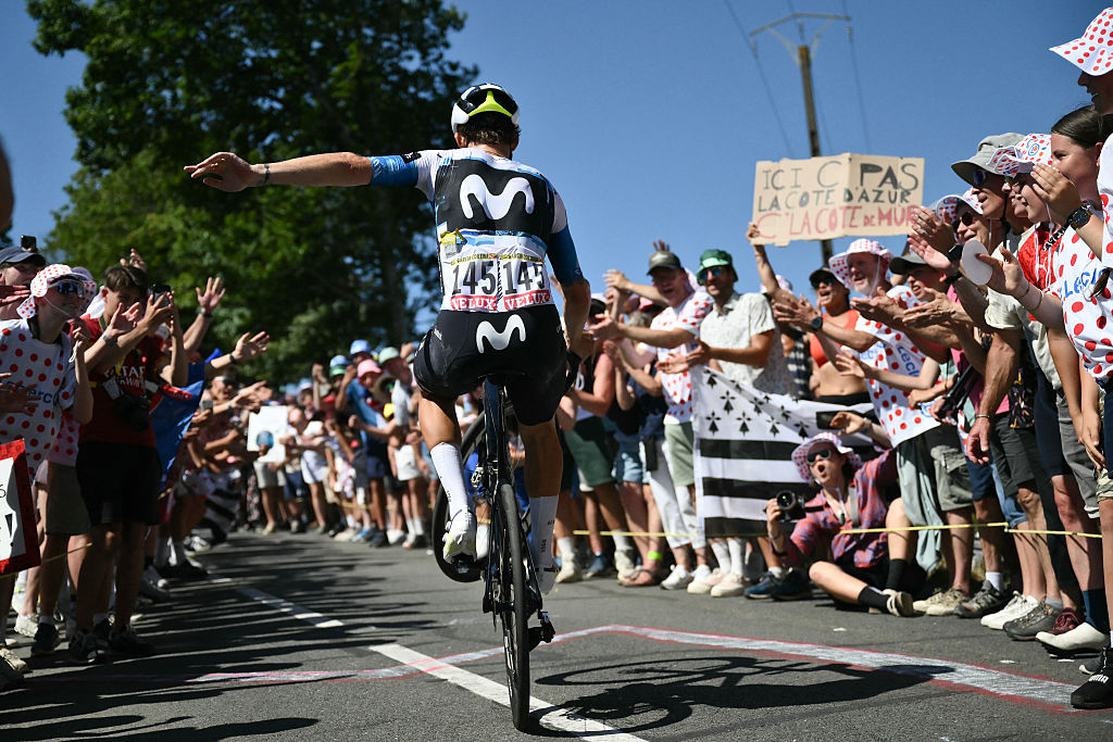 Movistar Team's Spanish rider Ivan Garcia Cortina performs a wheely as he cycles in the ascent of Mur-de-Bretagne in the final kilometres of the 7th stage of the 112th edition of the Tour de France cycling race, 197 km between Saint-Malo and Mur-de-Bretagne Guerledan, in Brittany, western France, on July 11, 2025. (Photo by Marco BERTORELLO / AFP)