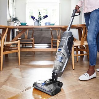 room with steam mop machine and wooden flooring