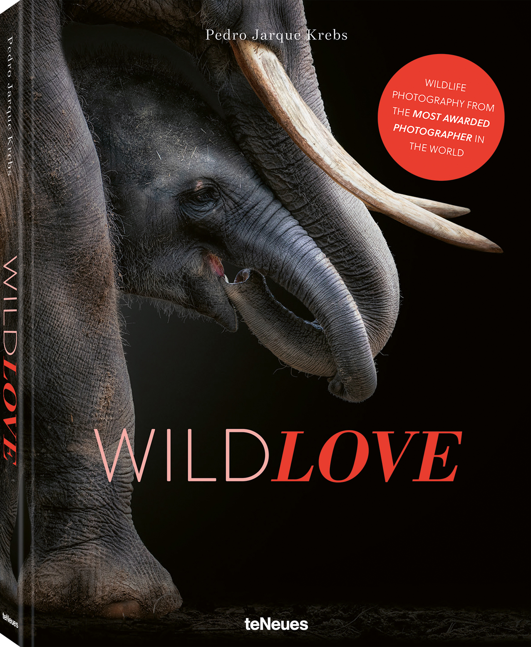 A book cover: close-up of an elephant's trunk gently touching a calf, showcasing the bond between them. The black background enhances the intimate mood. Title reads "WILD LOVE"