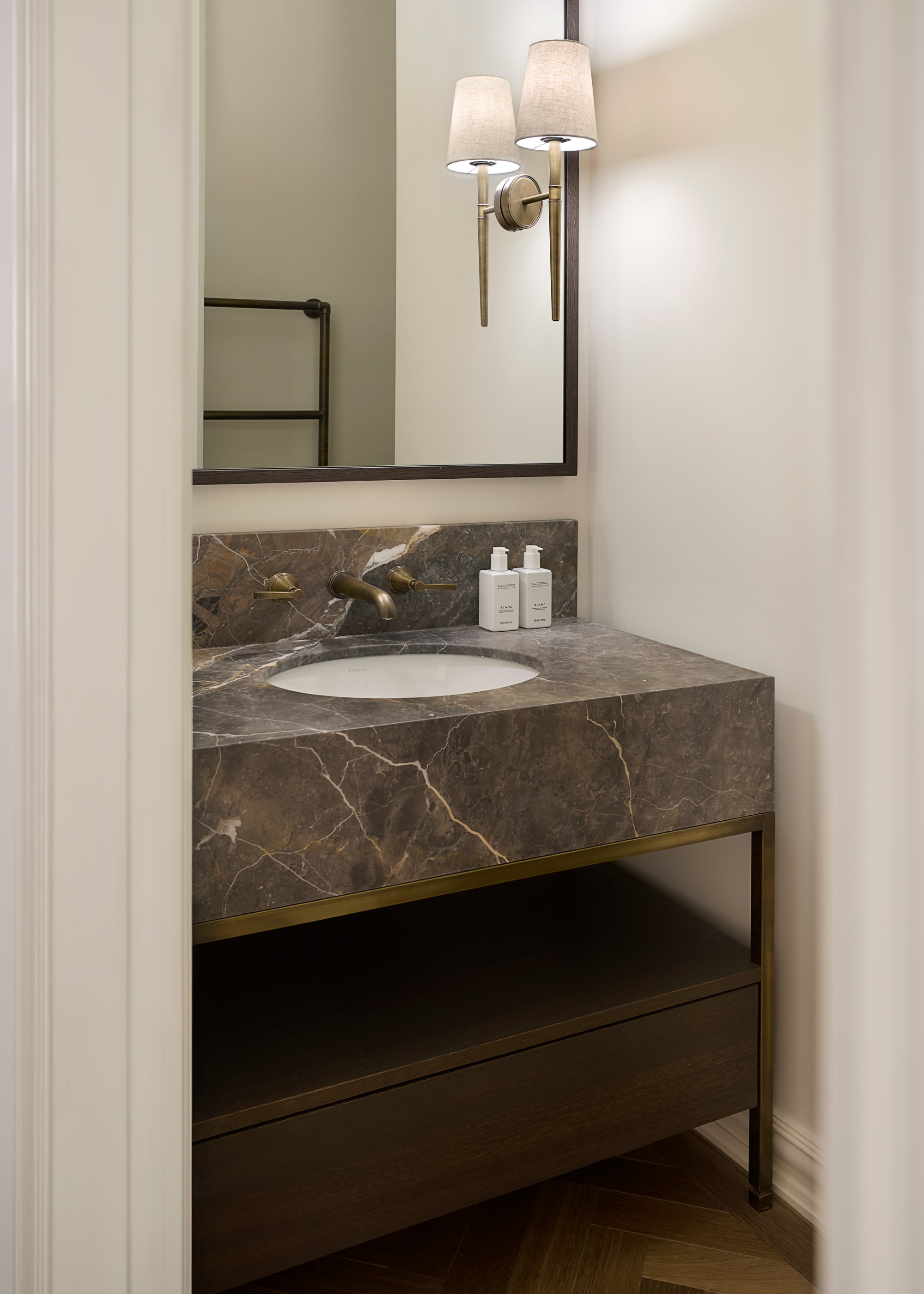 small bathroom vanity with dark brown marble counters