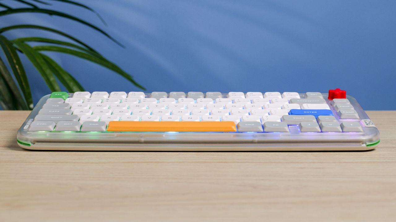The NuPhy Kick75 on a wooden surface with a blue wall in the background