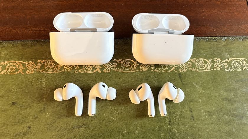 The AirPods Pro 3 and AirPods Pro 2 buds below their charging cases on a green material surface.