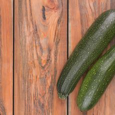 Two zucchinis on a wooden surface