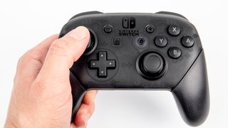 Nintendo Switch Pro controller held in a person's left hand