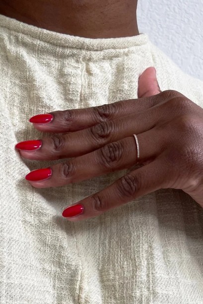 A model with poppy red nails.