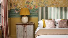 Bedroom with yellow wallpaper and aged wood nightstand