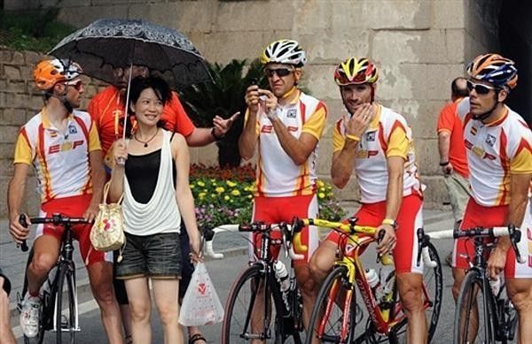 A local fan poses for a photo with Spain's cycling team.
