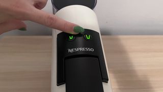 Selecting cup size on a Nespresso pod coffee machine