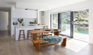 kitchen with white interiors and wooden dining table and bench
