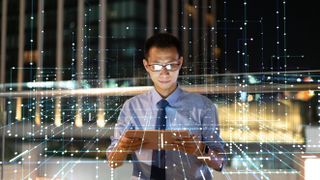 Person in suit with grid of data and tablet