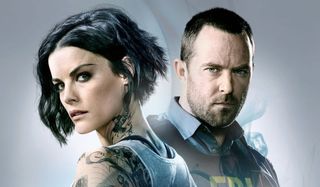 Blindspot Jaimie Alexander and Sullivan Stapleton stand in front of a smoky background