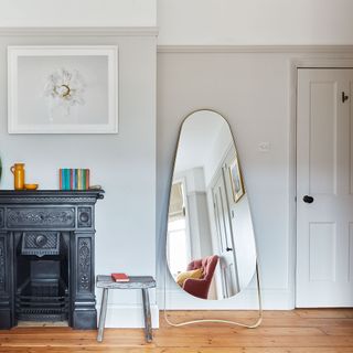 grey bedroom with fireplace and mirror